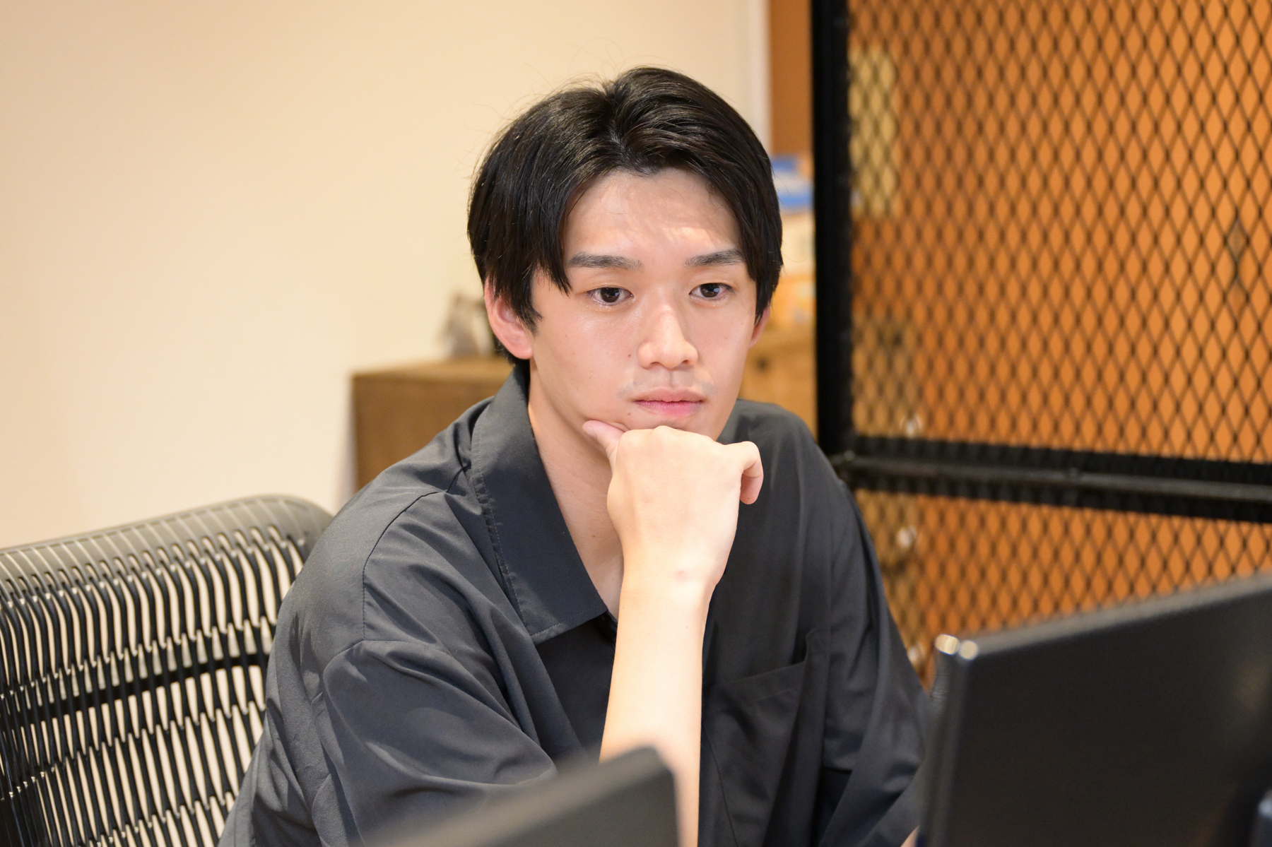 2022年にキャリア入社したクラウドソリューションチームの男性メンバーが、白色のTシャツ姿で手を後ろに組んでにこやかにこちらを見ています。